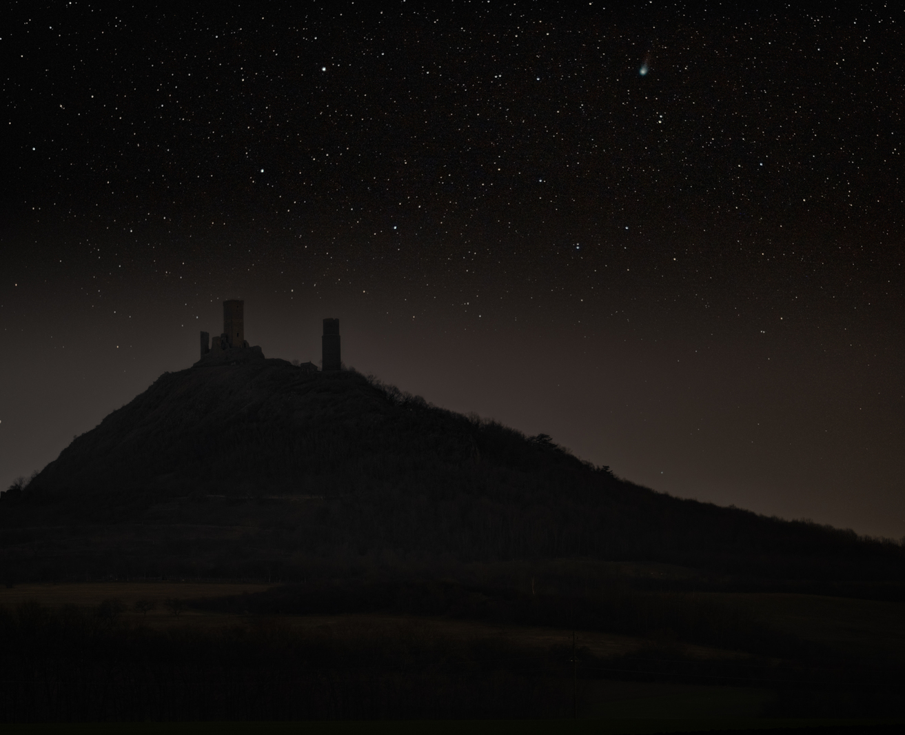 Hazmburk castle at night with stars and 12P/Pons–Brooks
      comet